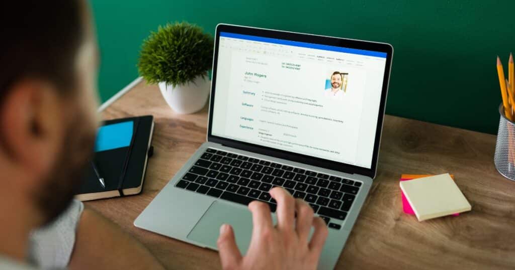 Person reviewing a resume on a laptop screen, representing ats software development and modern ats solutions for candidate evaluation